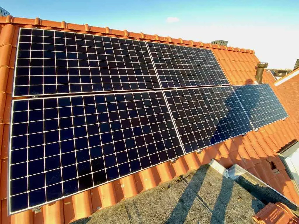 lange schaduw van een installateur op een zonnepanelen systeem in de winter