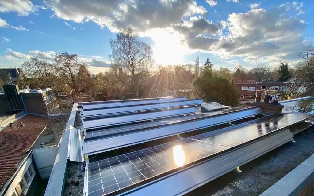Zonnepanelen op een plat dak met laagstaande zon in januari 2023