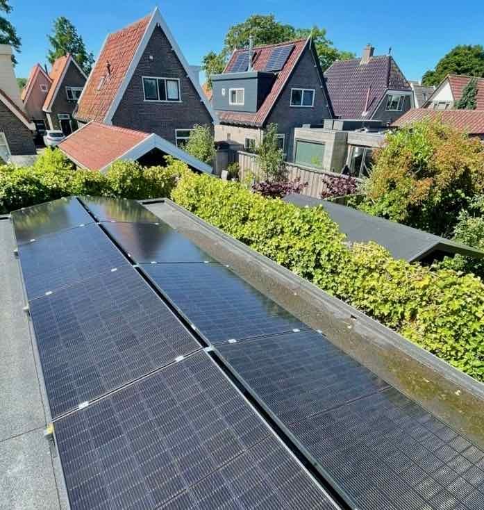 zonnepanelen met uitzicht op puntdaken in een blauwe lucht, juli 2022