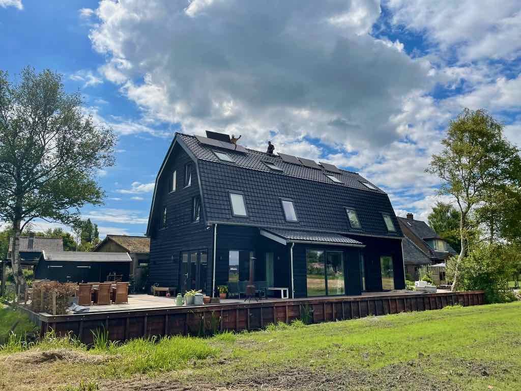 monteurs aan het werk op het dak met blauwe lucht en wolken
