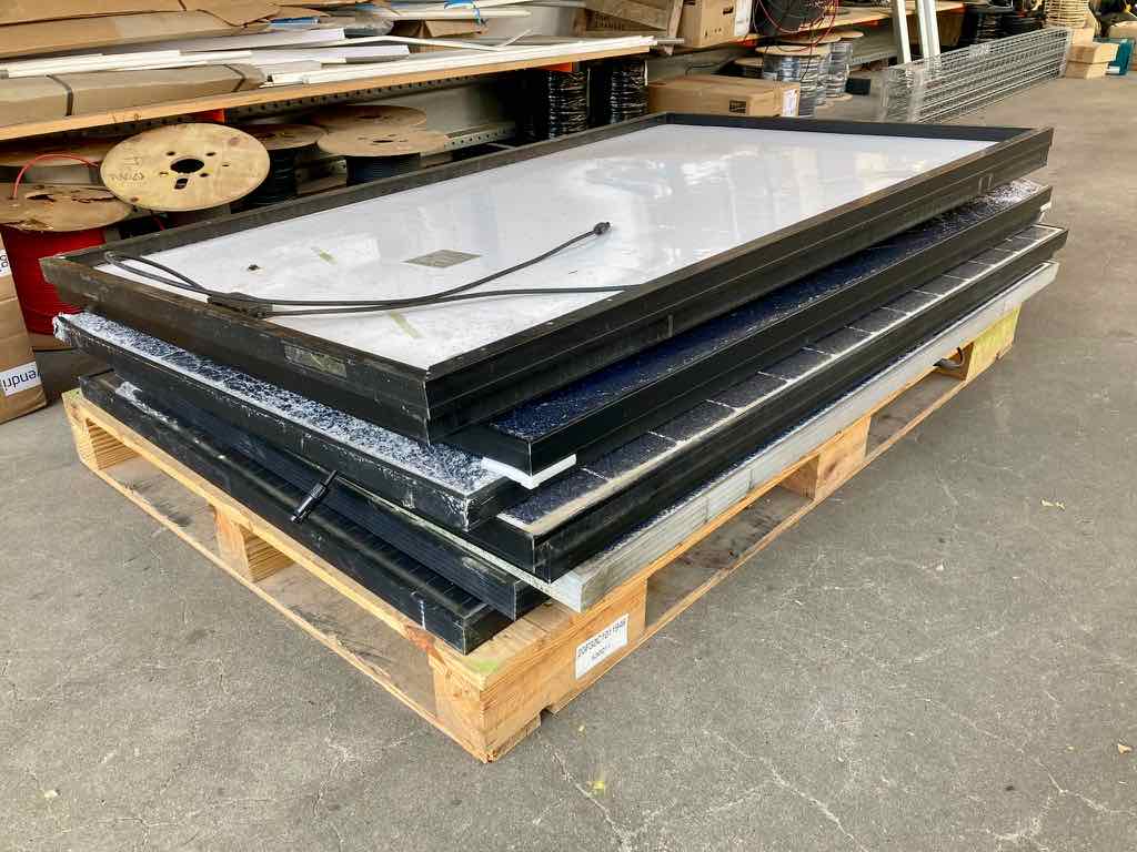 Kapotte zonnepanelen in de loods van Zonnefabriek. Nog niet genoeg om opgehaald te worden..