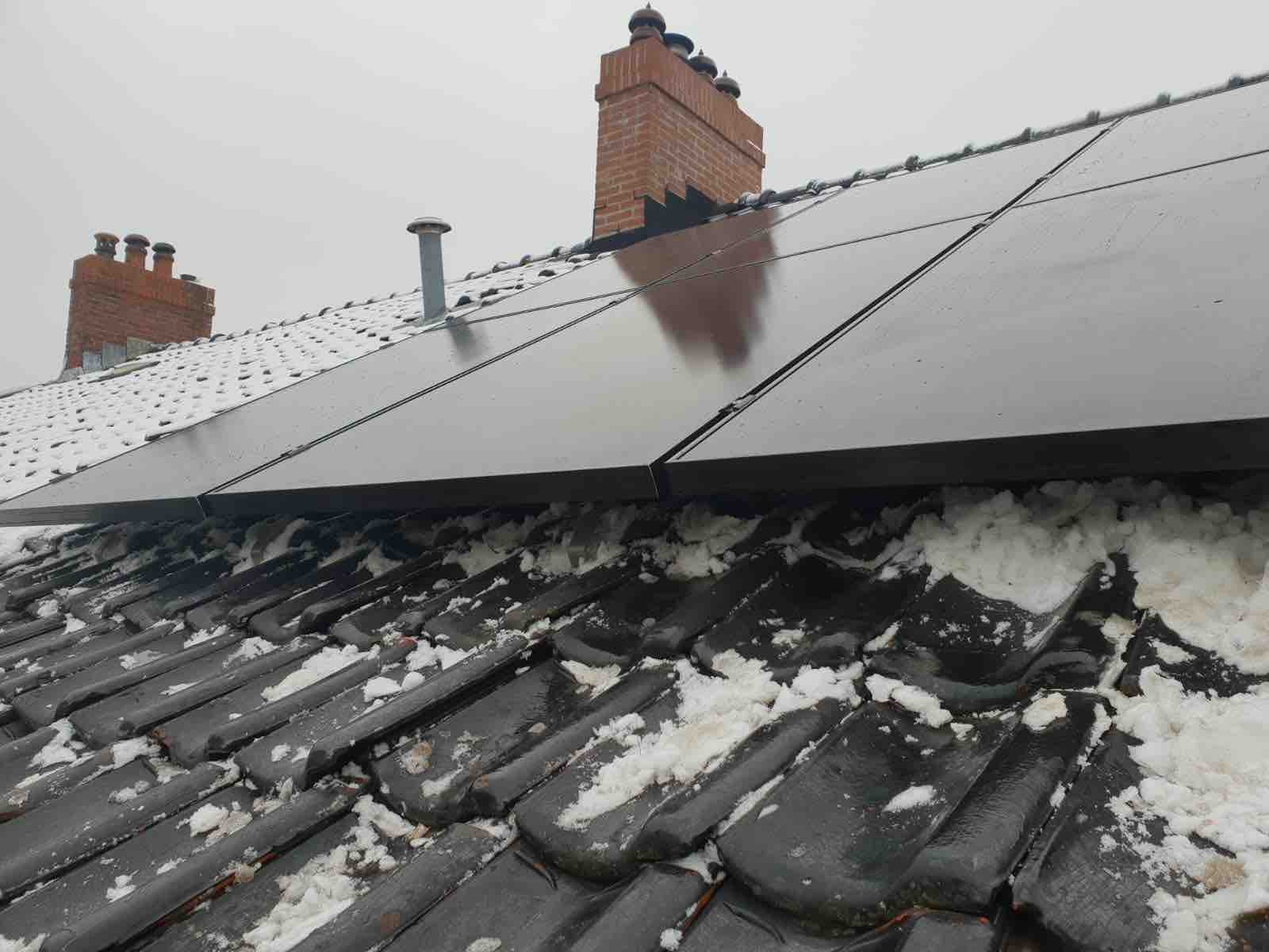 dak met panelen en sneeuw